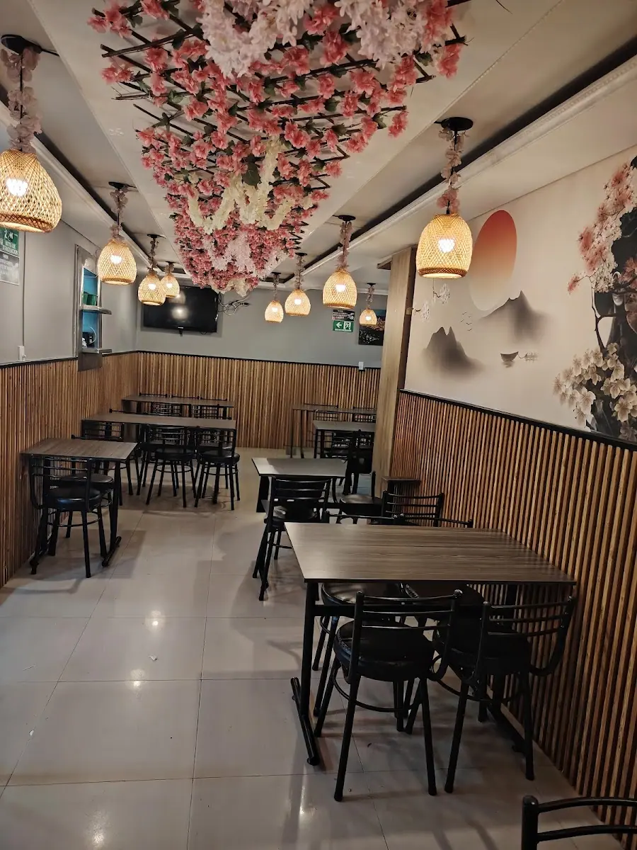 Salón de Sushi Plus Chicken con techo de cerezos, lámparas de mimbre y paredes de guadua