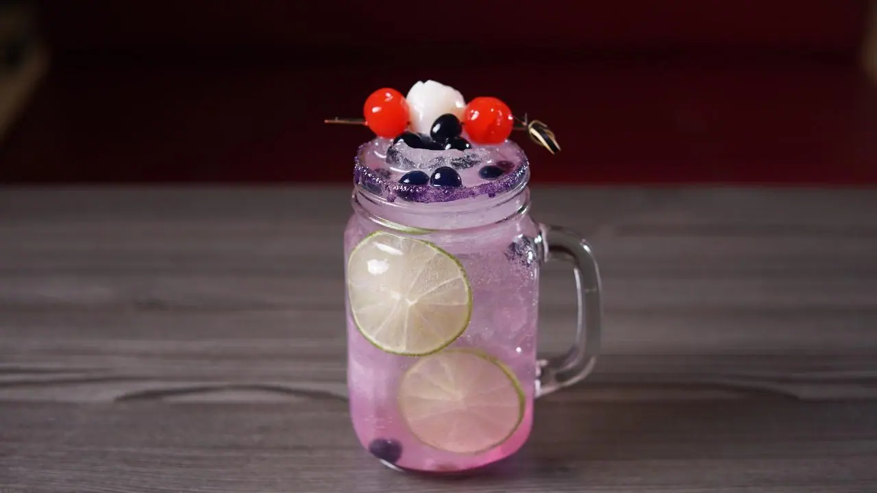 Soda italiana de frutos del bosque servida en jarra de vidrio